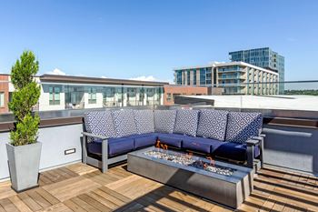 A blue couch with a white patterned cushion is on a wooden deck at Regatta Sloans Lake Apartments, Denver, CO, 80204